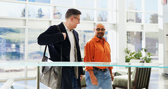 Two people walking in an office